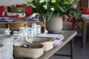 houten tafel met witte bloemen, borden, glazen, bestek en menukaarten