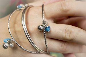 hand met armbanden, zilver en blauwe details