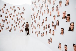 expositieruimte met allemaal gezichten op een witte muur