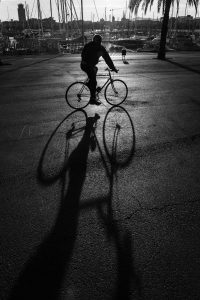 fietser en schaduw in haven barcelona