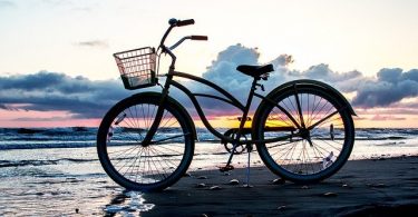 fiets op strand bij ondergaande zon