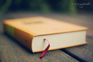 geel boek met rood lint erin op een houten tafel