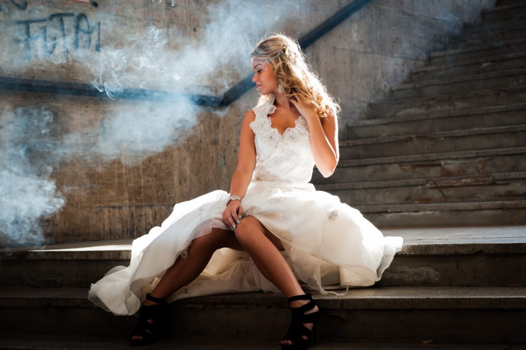 bruid in bruidsjurk zit op trap