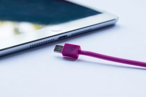 close up van ipad met paarse lightning kabel