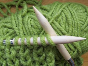 breinaalden met groene garen