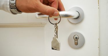 hand en sleutel aan deurklink