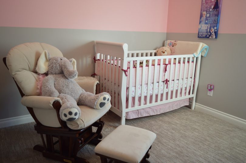 babykamer met bed stoel roze behang
