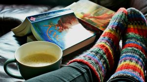 wollen regenboogsokken met boek en kop koffie