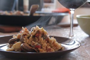 paella op bord met glas rode wijn