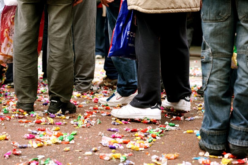 straat met mensen en snoepgoed op de grond