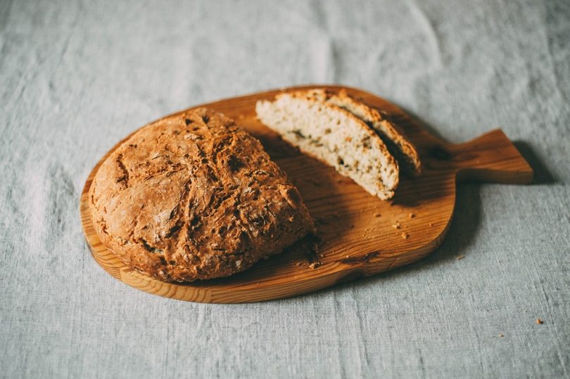 meergranenbrood op houten plank en linnen tafelkleed