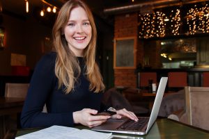 lachende vrouw met telefoon en laptop