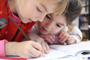 twee meisjes leren schrijven