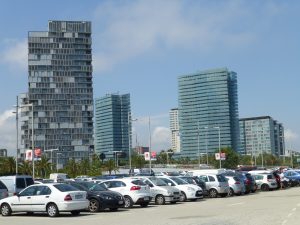 hoge flatgebouwen met grote parkeerplaats op voorgrond