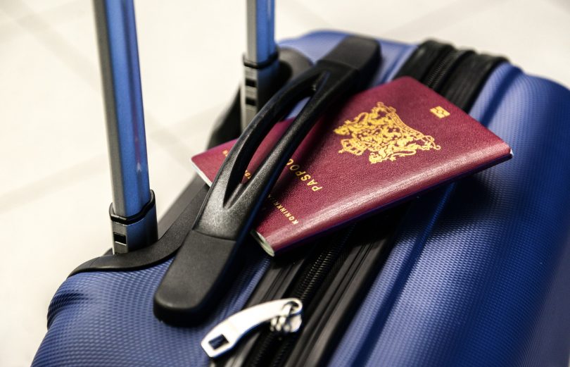 blauw koffer met paspoort