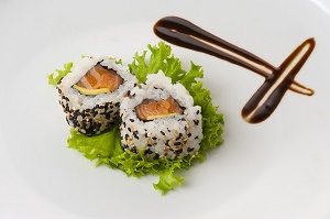 twee stukjes sushi met zalm op blaadje sla