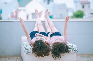 two women in pink lying on a sofa together