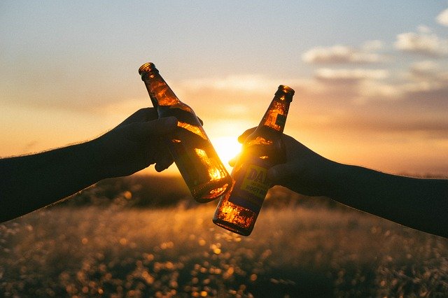 two hands with beer bottle