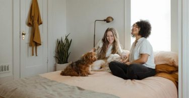 twee vrouwen met hond op bed