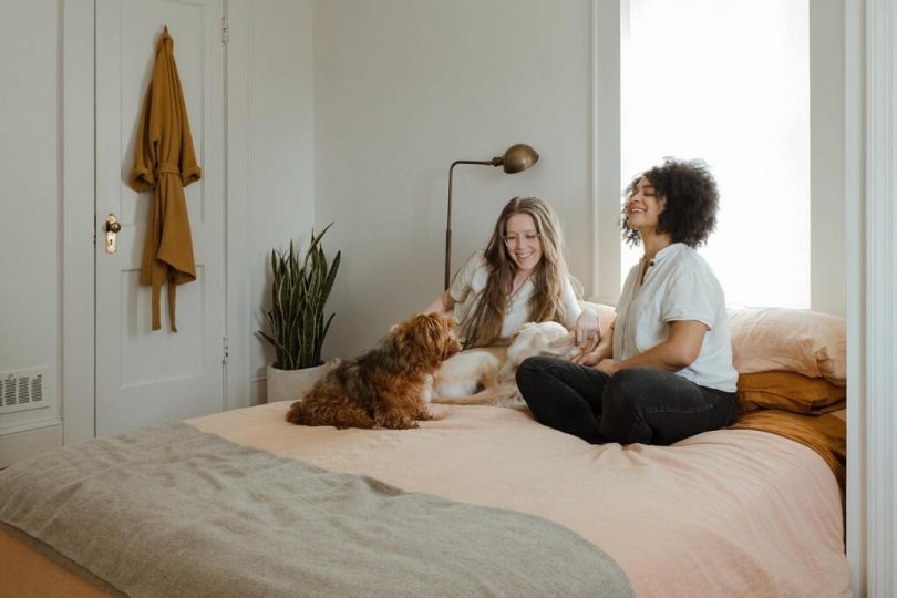 twee vrouwen met hond op bed